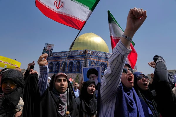 Iranian protesters chant slogans as one of them holds up a portrait of Iran's Revolutionary Guard aerospace division commander, Gen. Amir Ali Hajizadeh, who was killed in an Israeli strike on Iran, in front of a model of Jerusalem's Dome of the Rock mosque, during a protest to condemn Israeli attacks on multiple cities across Iran, after Friday prayers ceremony in Tehran, Iran, Friday, June 20, 2025. (AP Photo/Vahid Salemi)