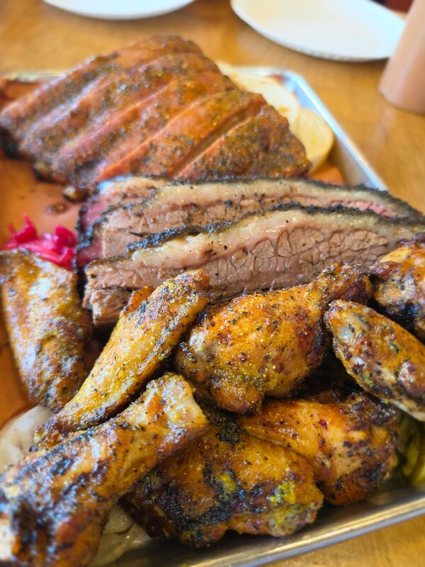 The smoked chicken wings from Owens & Co. come in lemon pepper and sassy seasoning. (Justin Brown for the AJC)