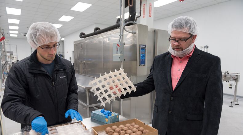 Keith Schroeder, right, founder and chief executive officer of High Road Ice Cream & Sorbet, and Grayson Shurett, left, a worker at High Road, examine ice cream scoops in High Road's factory in Marietta, Georgia (DAVID BARNES / SPECIAL)