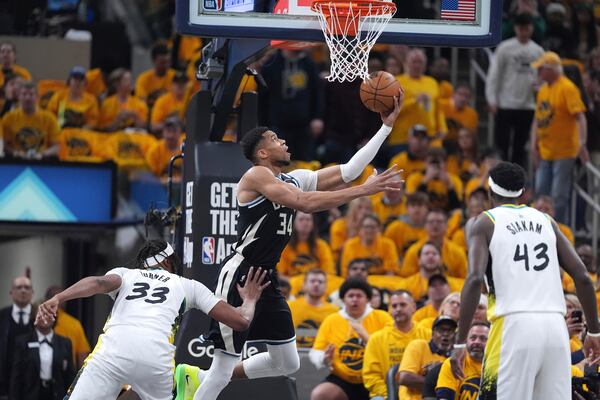 Milwaukee Bucks' Giannis Antetokounmpo (34) heads to the basket as Indiana Pacers' Myles Turner (33) and Pascal Siakam (43) defend during the first half of a first-round NBA basketball playoff game, Saturday, April 19, 2025, in Indianapolis. (AP Photo/Michael Conroy)