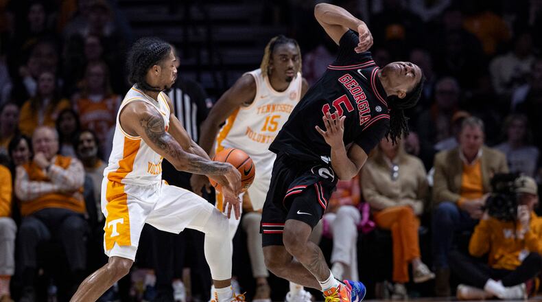 Georgia guard Silas Demary Jr. (5) falls back as he collides with Tennessee guard Zakai Zeigler (5) while battling for the ball during the first half of an NCAA college basketball game Wednesday, Jan. 15, 2025, in Knoxville, Tenn. (AP Photo/Wade Payne)