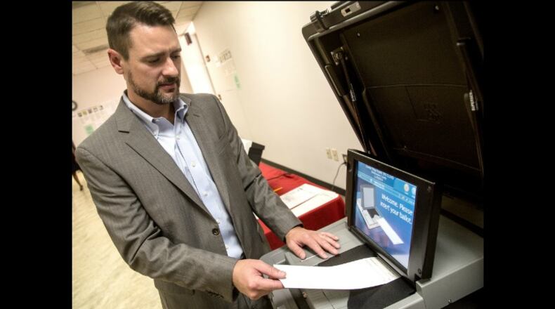 Jeb Cameron with Election Systems & Software demonstrates the paper ballot voting machines at Rockdale County Board of Elections in Conyers, where a test run of the machines was conducted during November’s elections. STEVE SCHAEFER / SPECIAL TO THE AJC