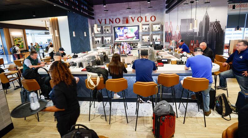 Travelers dine at Vino Volo in the new location in Terminal T at Hartsfield-Jackson International Airport on Wednesday, May 1, 2024, in Atlanta. Vino Volo is one of multiple shops opened last year by concessions giant Paradies Lagardère, a global corporation that offers retail and dining experiences to travelers. (Miguel Martinez/AJC)