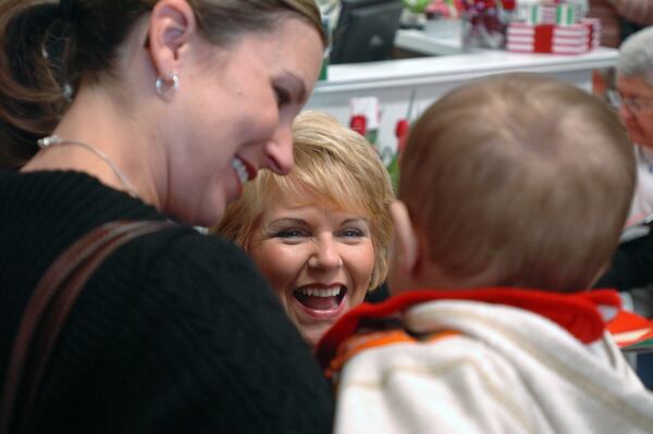 071129: Acworth, GA: Carol Aebersold (CQ) (center) gets a laugh out of Jennifer Rodda (CQ) and her 8-month-old son John Henry Rodda (CQ) while signing copies of the book "Elf on a Shelf" at the Pink Crocodile in Acworth on Thursday Nov. 29, 2007. (FRANK NIEMEIR/Staff)
