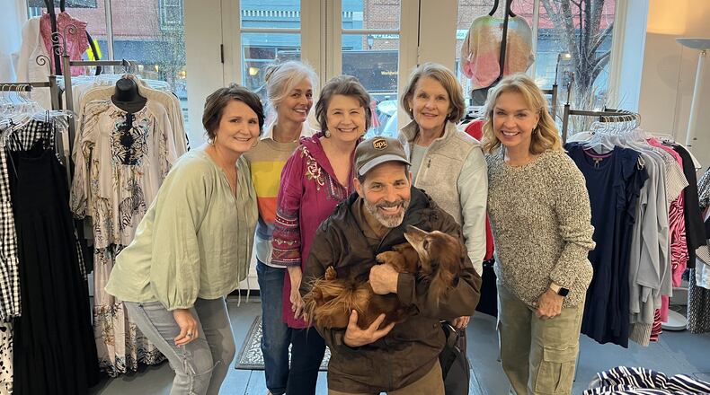 The crew at Amelia’s Accessories gathers with UPS driver Randy Pace on his last day in Madison. Pictured are Agnes Jones, Angela Cosby, Lydia Bennett, Pace with River, Frannie Hilsman and Amelia’s owner Kim Jensen. (Handout)