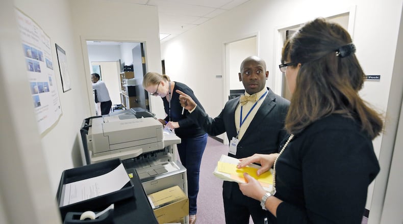 Michael Cuffee, assistant to the City Manager, confers with Michelle Macauley (right), Interim Director of Development Services, as the Development Services department prepares to begin building inspections on Wednesday.  BOB ANDRES /BANDRES@AJC.COM