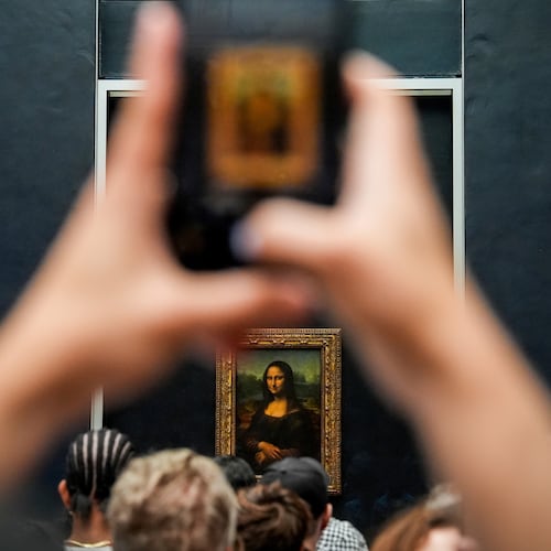 FILE - A person photographs Leonardo da Vinci's painting Mona Lisa at the Louvre museum, Aug. 31, 2025, in Paris. (AP Photo/Julia Demaree Nikhinson, file)