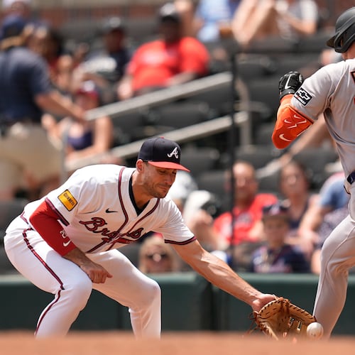 San Francisco Giants' Patrick Bailey (14) beats the tag by Atlanta Braves first baseman Matt Olson (28) in the seventh inning of a baseball game, Wednesday, July 23, 2025, in Atlanta. (AP Photo/Mike Stewart)