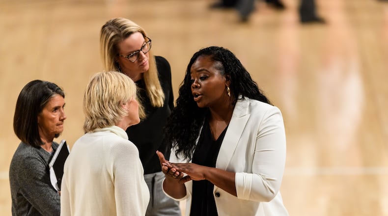 Georgia Tech assistant coach Tasha Butts (right) confers with the Yellow Jackets coaching staff during a Dec. 5, 2019 game against Wisconsin at McCamish Pavilion. (Danny Karnik/Georgia Tech Athletics)