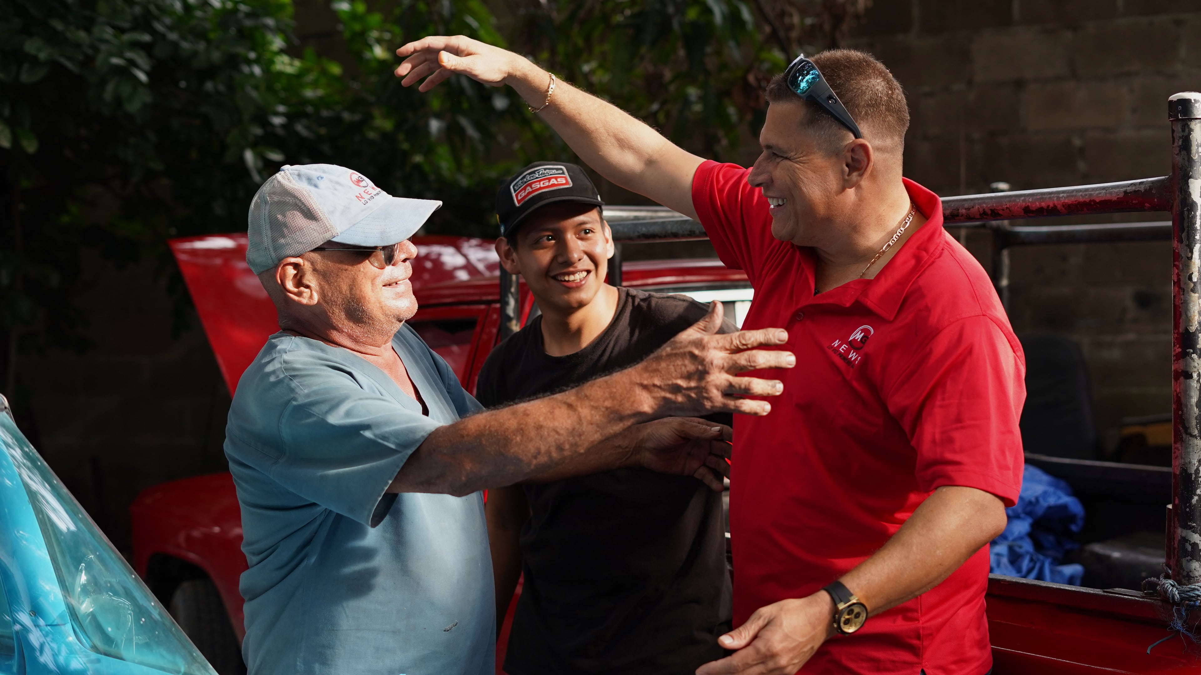 Salvadoran journalist Mario Guevara, right, greets neighbors after arriving at a relative's home in Apopa, El Salvador, following his deportation from the United States, Friday, Oct. 3, 2025. (AP Photo/Salvador Melendez)