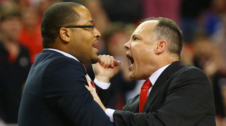 Assistant coach Jonas Hayes trys to pull Georgia head coach Mark Fox off the court after he was called for a technical foul for arguing an official's call during the second half against Ole Miss in a SEC Men's Basketball Tournament game on Friday, March 14, 2014, in Atlanta. CURTIS COMPTON / CCOMPTON@AJC.COM