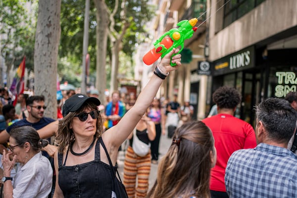 A protester holds a water gun during a protest against overtourism in Barcelona, Spain, Sunday, June 15, 2025. (AP Photo/Pau Venteo)