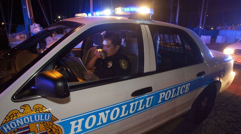 A Honolulu police officer talks into his public address system in this March 2011 photo. (AP Photo/Eugene Tanner)
