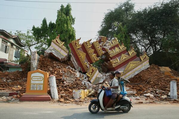 In this photo released by Xinhua News Agency, locals past by a collapsed building in the aftermath of an earthquake in Mandalay, Myanmar on Saturday, March 29, 2025 (Myo Kyaw Soe/Xinhua via AP)