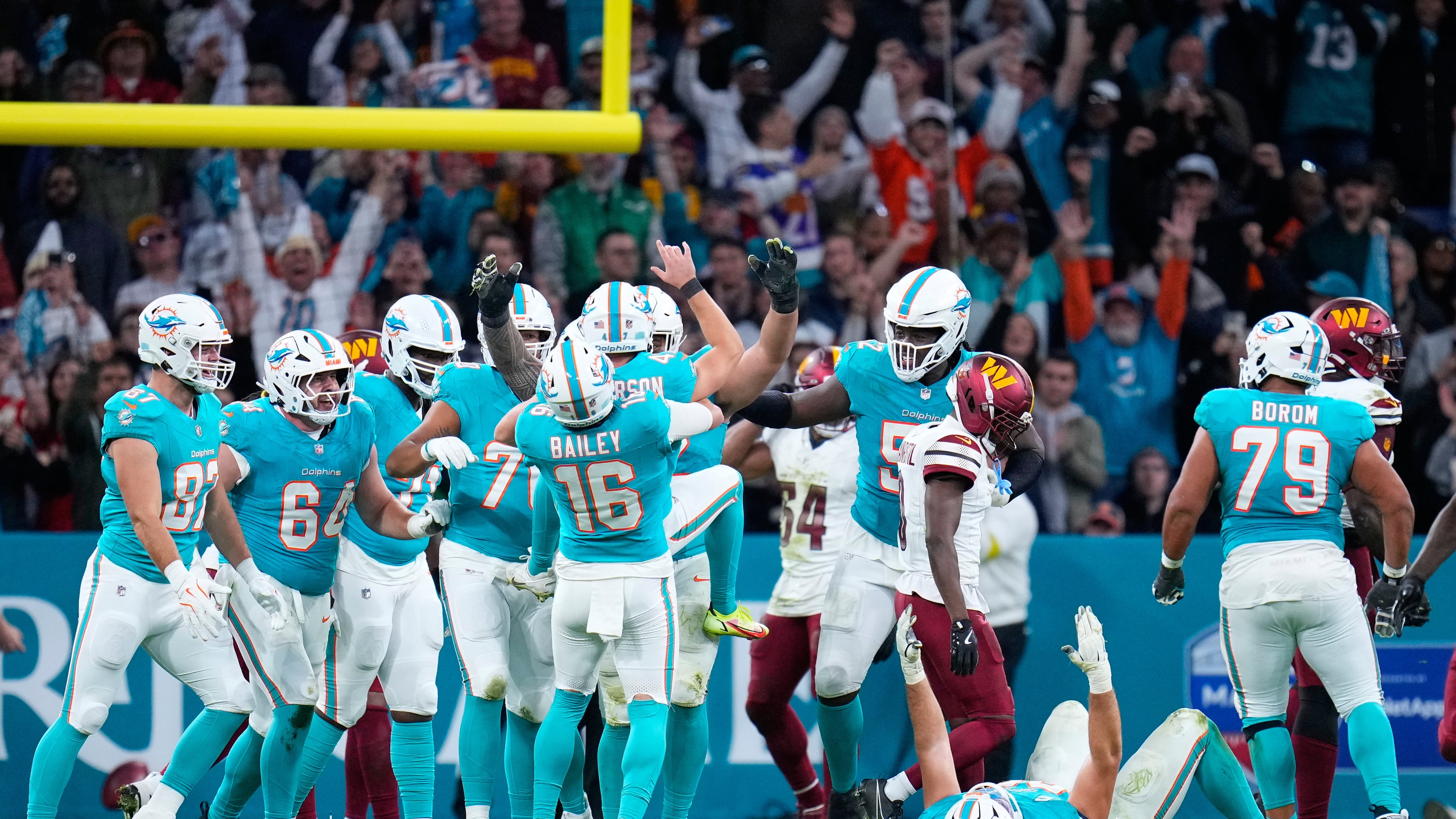 Miami Dolphins players celebrate with place kicker Riley Patterson (47) after his kicked a field goal during overtime to win an NFL football game between the Washington Commanders and the Miami Dolphins in Madrid, Spain, Sunday, Nov. 16, 2025. (AP Photo/Manu Fernandez)