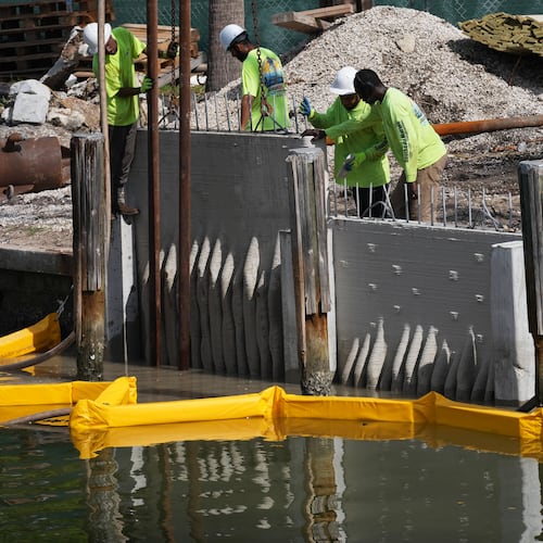 Workers install a 3D-printed living seawall manufactured by Kind Designs at the Church by the Sea, Tuesday, Aug. 4, 2026, in Fort Lauderdale, Fla. (AP Photo/Lynne Sladky)