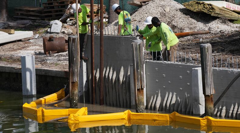 Workers install a 3D-printed living seawall manufactured by Kind Designs at the Church by the Sea, Tuesday, Aug. 4, 2026, in Fort Lauderdale, Fla. (AP Photo/Lynne Sladky)