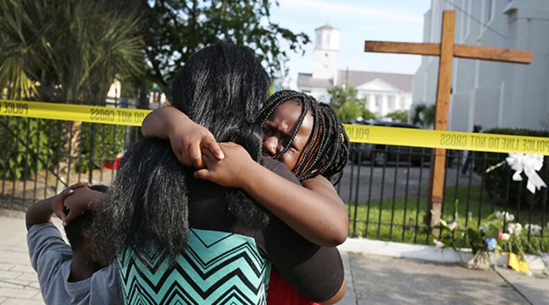 Kearston Farr comforts her daughter, Taliyah Farr, 5, as they stand in front of the Emanuel African Methodist Episcopal Church after a mass shooting at the church that killed nine people of June 19, 2015. A 21-year-old white gunman is suspected of killing nine people during a prayer meeting in the church, which is one of the nation's oldest black churches in Charleston. (Photo by Joe Raedle/Getty Images)