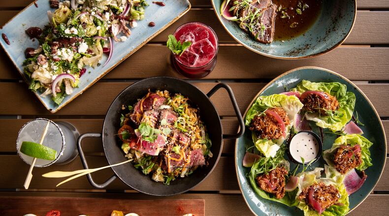 UP on the Roof's menu includes Harvest Salad (upper left), Tuna Tataki (upper right), Honey-Soy Fried Chicken Lettuce Wraps (lower right), Kobe Steak Gyudon Skillet (center), Humpty Dumpties (lower left), and Black Dahlia and To "Quila" Mockingbird cocktails. (Mia Yakel for The Atlanta Journal-Constitution)