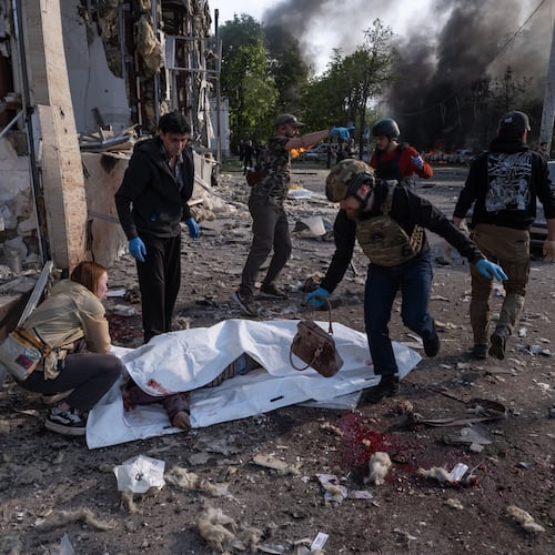 In this photo provided by Ukraine's 93rd Kholodnyi Yar Separate Mechanized Brigade press service, people cover bodies of civilians killed in Russia's aerial guided bomb attack in Kramatorsk, Donetsk region, Ukraine, Tuesday, May 5, 2026. (Iryna Rybakova/Ukraine's 93rd Mechanized Brigade via AP)