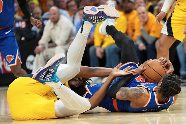 New York Knicks guard Miles McBride, right, tries to control the ball next to Indiana Pacers center Myles Turner during the second half of Game 3 of the Eastern Conference finals of the NBA basketball playoffs Sunday, May 25, 2025, in Indianapolis. (AP Photo/AJ Mast)