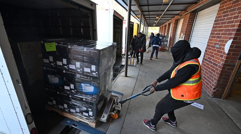 An elections worker unloads a batch of new voting machines at Fulton County Election Preparation Center in Atlanta on Tuesday, Jan. 21, 2020. Truckloads of voting machines are arriving at a large Atlanta-area warehouse, where workers are unloading piles of cardboard boxes before a critical deadline: the March 24 presidential primary. (Hyosub Shin / Hyosub.Shin@ajc.com)