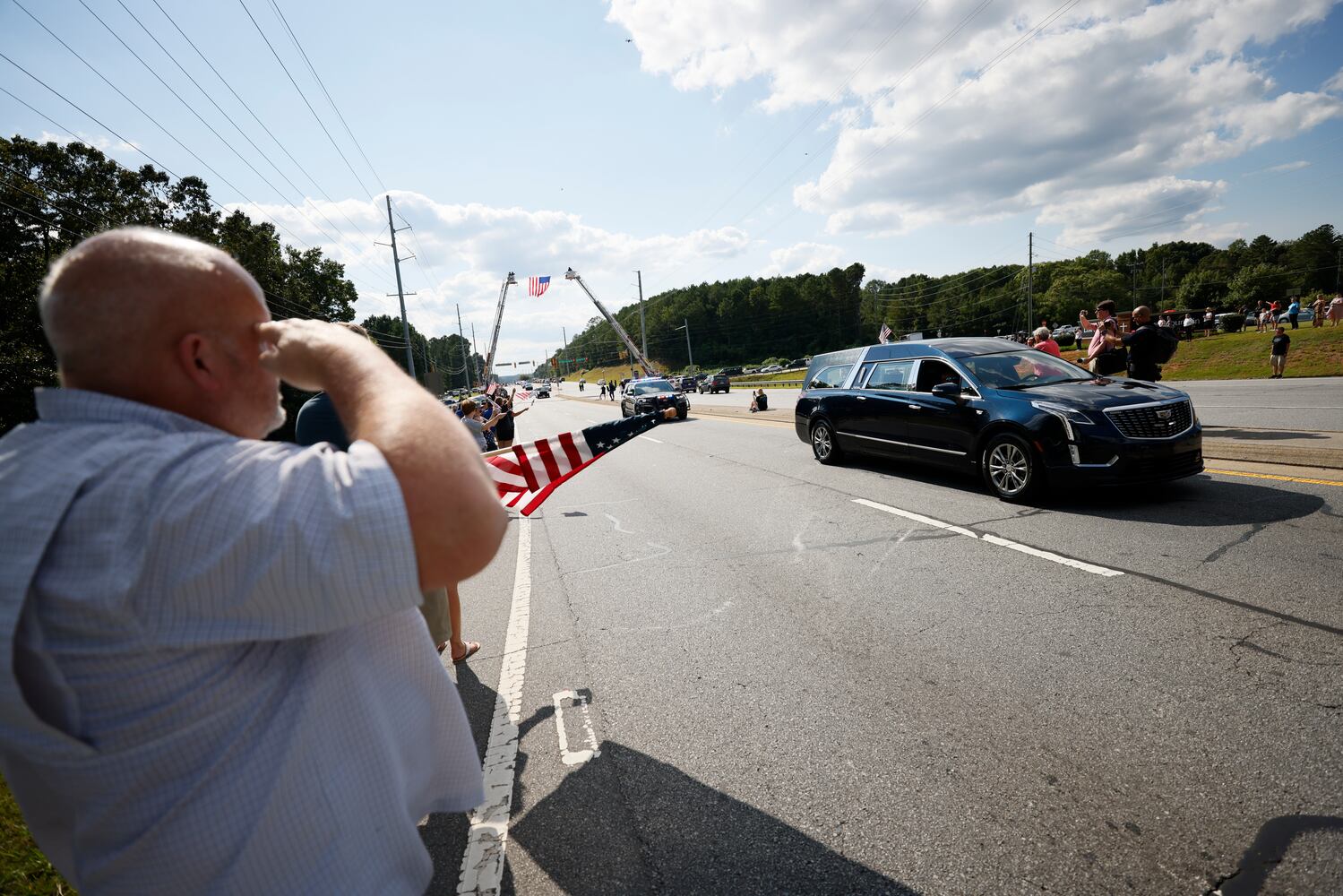 Marietta Police Department retiree Don Smith, salutes the hearse of Marshall  Marshall Samual Ervin Jr as the procession pass by Dallas Highwy in Paulding County on Thursday, September 15, 2022.  Marshall Samual Ervin Jr, alongside Cobb County Sheriff Deputy Koleski, was killed late Thursday while attempting to arrest Christopher James Cook Jr. at home in the Hampton Glen subdivision last week.
Miguel Martinez / miguel.martinezjimenez@ajc.com 