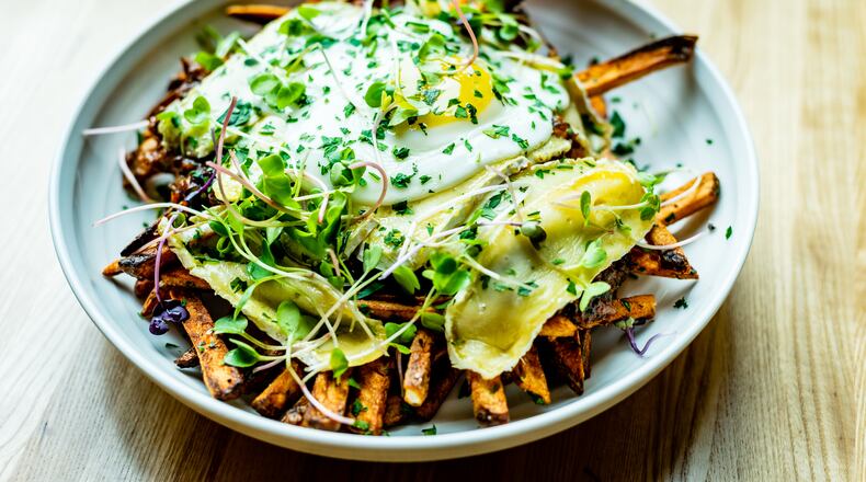 The disco frites at Tin Tin include duck "gravy," brie and a fried duck egg.
