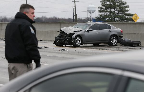 January 7, 2017, Covington: A Department of Natural Resources officer helps work the scene of a multi-vehicle accident on I-20 West at Alcovy Road on an icy bridge overpass as temperatures drop below freezing on Saturday, Jan. 7, 2017,  in Covington.    Curtis Compton/ccompton@ajc.com