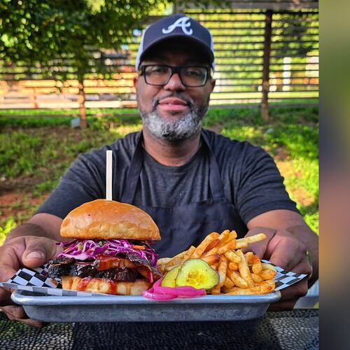Jimmie Jackson of Jimmie's Jerk Barbecue and his brisket sandwich. (Courtesy of Jimmie's Jerk Barbecue)