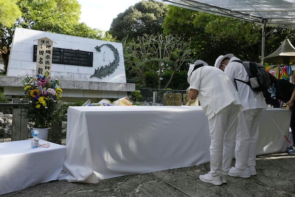 People pray in front of the Himeyuri Cenotaph in Itoman, Okinawa, southern Japan Monday, June 23, 2025 as Japan marked the 80th anniversary of the end of the Battle of Okinawa. (Naoki Hiraoka/Kyodo News via AP)