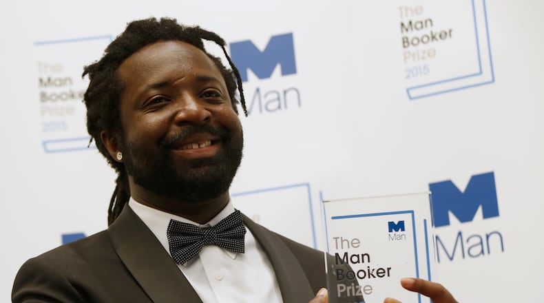 FILE - Marlon James poses with the award after his book 'A Brief History of Seven Killings' was named as winner of the 2015 Booker Prize 2015 for Fiction, following the award ceremony at the Guildhall in London, Tuesday, Oct. 13, 2015.(AP Photo/Alastair Grant, file)