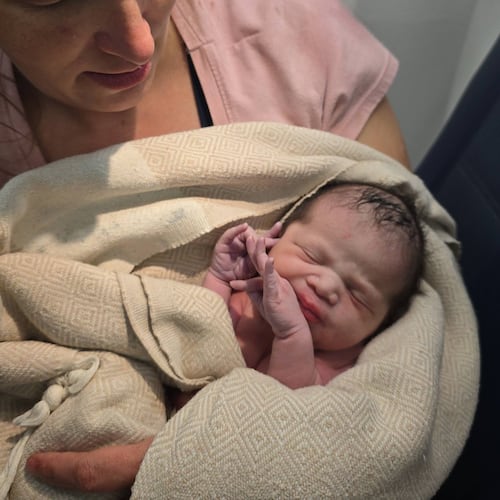 In this photo provided by Tina Fritz, Ashley Blair holds her daughter Brielle, who was born April 24, 2026, on a Delta Air Lines flight just as it was landing in Portland, Ore. (Tina Fritz via AP)
