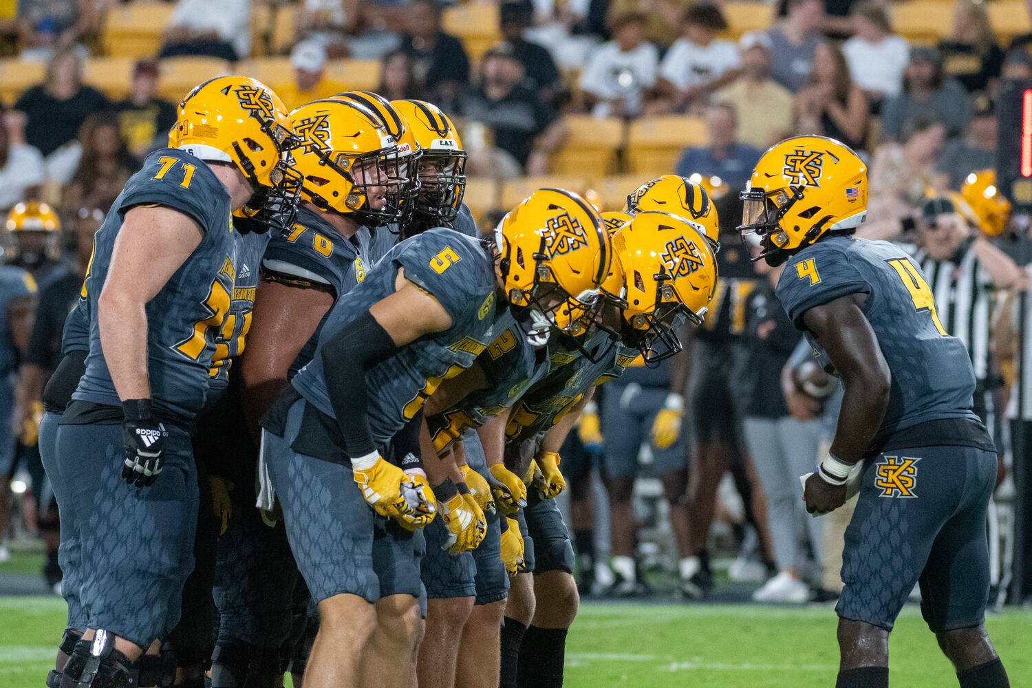 KSU's quarterback Jonathan Murphy huddles with his teammates. (Jamie Spaar for the Atlanta Journal Constitution)