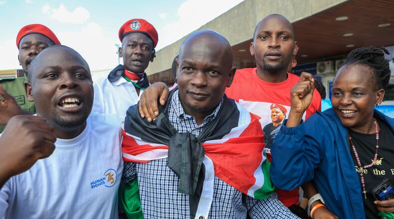Kenyan human rights activist Nicholas Oyoo, centre, arrives at Jomo Kenyatta International Airport (JKIA) in Nairobi, Kenya, Saturday, Nov. 9, 2025. (AP Photo/Andrew Kasuku)