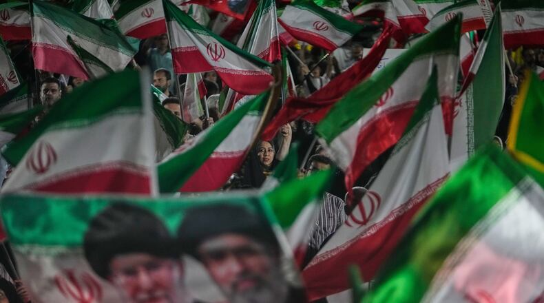 Pro-government Iranian demonstrators wave Iranian flags and a portrait of the Supreme Leader Ayatollah Mojtaba Khamenei, right, and his slain father Ayatollah Ali Khamenei in a gathering at a square in Tehran, Iran, Friday, May 29, 2026. (AP Photo/Vahid Salemi)