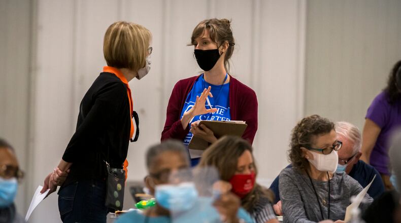 Poll watchers discuss a ballot as auditors sort ballots during an audit at the Chatham County Board of Elections Annex building, Saturday in Savannah, Ga. (AJC Photo/Stephen B. Morton)