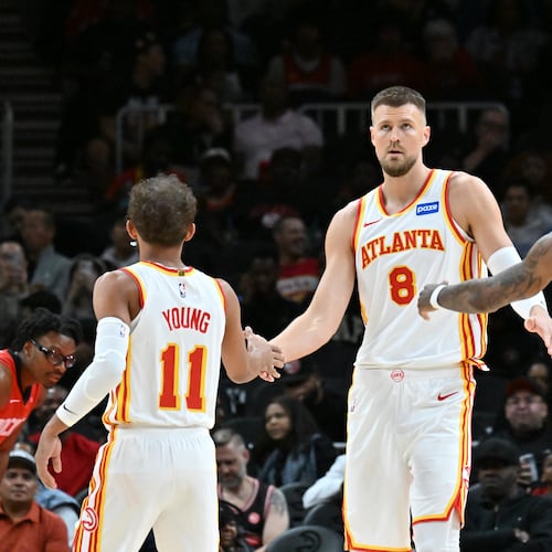 Atlanta Hawks' Kristaps Porziņģis celebrates with Trae Young and Nickeil Alexander-Walker during the first half in a preseason NBA basketball game at State Farm Arena, Thursday, October 16, 2025, in Atlanta. The Hawks will open the regular season next week against the Raptors. (Hyosub Shin/AJC)