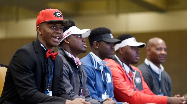 Pace Academy players are arrayed in the colors of their chosen schools during last year's National Signing Day. Trey Blount, in the Georgia hat, is in the foreground. (DAVID BARNES / DAVID.BARNES@AJC.COM)