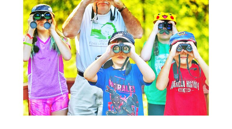 The Lil Birdie Rascals birding team looks for birds from Charles Seabrook's backyard deck in Decatur. From left to right are Ella Ballard, 11; Seabrook; Declan Pease, 8; Eden Ballard, 9; and Elias Parga-Tang, 7. (Courtesy of Daniel Ballard)