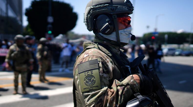 FILE - An ICE Special Response Team member stands guard outside the Metropolitan Detention Center, while protesters gather outside to denounce the ICE, U.S. Immigration and Customs Enforcement, operations, June 10, 2025, in downtown Los Angeles. (AP Photo/Eric Thayer, File)