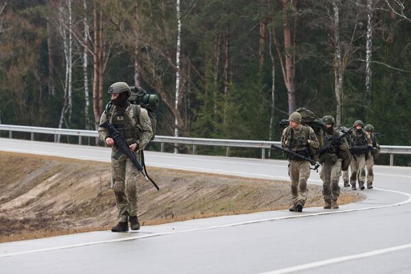 Soldiers walk along a road near a training range in Pabrade, north of the capital Vilnius, Lithuania on Thursday, March 27, 2025. (AP Photo/Mindaugas Kulbis)