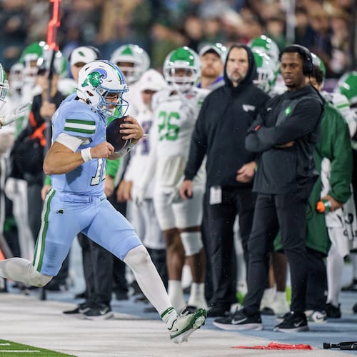 Tulane quarterback Jake Retzlaff, front right, runs against North Texas cornerback Da'Veawn Armstead, second from front right, during the first half of the American Conference championship NCAA college football game in New Orleans, Friday, Dec. 5, 2025. (AP Photo/Matthew Hinton)