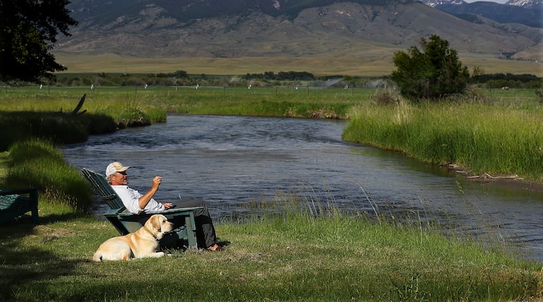 The wide-open spaces are outside Steve Bartkowski's back door in Montana - here he takes in the view from the banks of the Ruby River with the family dog Kua last summer. (Curtis Compton/ccompton@ajc.com
