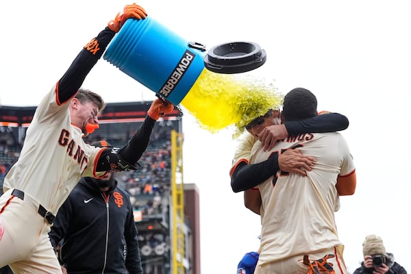 San Francisco Giants' Christian Koss, left to right, douses Jung Hoo Lee and Heliot Ramos after Ramos scored the game-winning run against the Texas Rangers after a baseball game Sunday, April 27, 2025, in San Francisco. (AP Photo/Godofredo A. Vásquez)