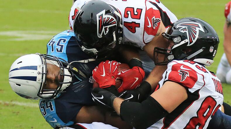 Titans' Avery Williamson intercepts a Matt Ryan pass in the end zone pulling the ball away from the Falcons' Jacob Tamme and Patrick DiMarco during the fourth quarter.