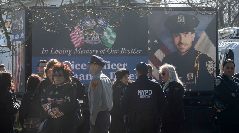 FILE - New York Police Department Officer Jonathan Diller is on a screen during his funeral service at Saint Rose of Lima R.C. Church in Massapequa Park, N.Y., March 30, 2024. (AP Photo/Jeenah Moon, File)