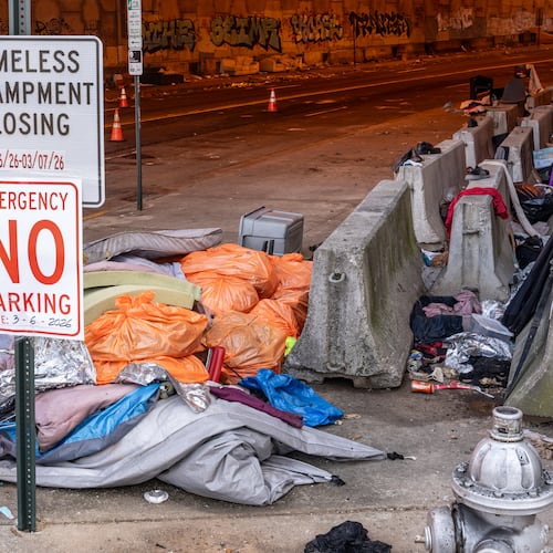 Trash is seen littered around a homeless encampment that runs along Leonard Tate Street under I-85 in downtown Atlanta. In recent years, homelessness policy in some of Georgia’s largest cities has drifted toward selective enforcement, guest columnist Victor Riches writes. (Ben Hendren for the AJC)