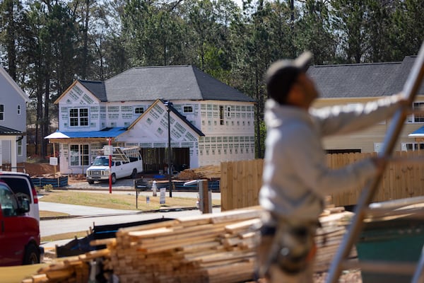 Workers build a single-family home in a development in South DeKalb