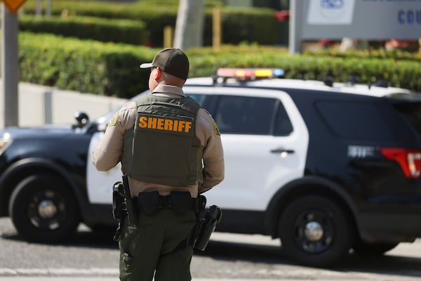 A sheriffs deputy monitors a street closure near the site of an explosion at the LA County Sheriff's Special Operations Bureau on Friday, July 18, 2025, in Los Angeles. (AP Photo/Etienne Laurent)